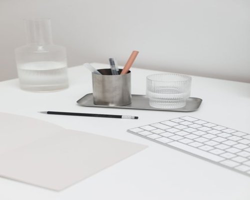 Organized modern workspace with proper natural lighting and a glass of water